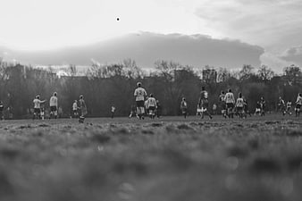 Black and White Football Match on Grass Field
