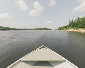 First-person view from a canoe speeding across a calm lake