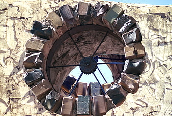 Rustic Round Stone Window with Metal Spokes