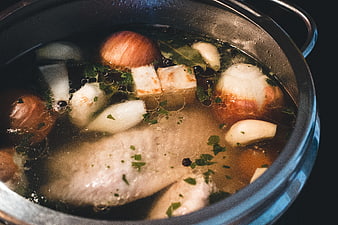 Simmering chicken broth with vegetables in a pot