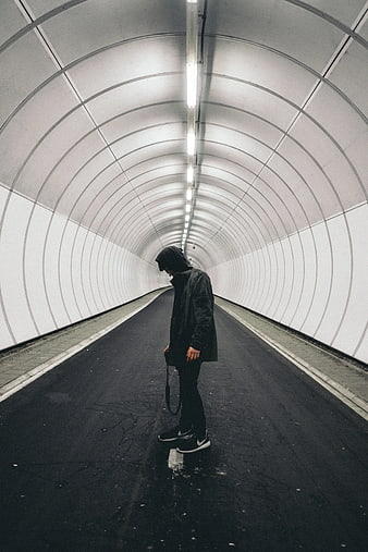 Man in Black Hoodie Standing in White Tunnel