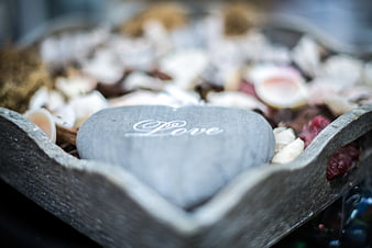 Heart-shaped stone with love text in wooden boat