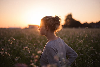 Woman in Flower Field at Sunset with Golden Hour Light