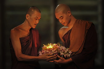 Two Buddhist Monks Holding Candle and Flowers