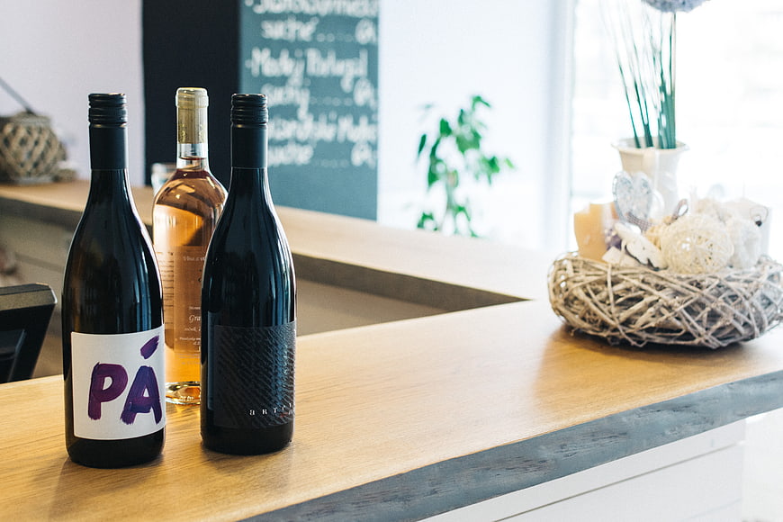 Wine bottles on a wooden bar counter with chalkboard background