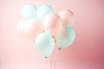 Pastel pink and blue balloons on a soft pink background