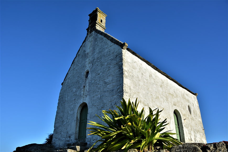 Low angle view of white stone chapel against blue sky