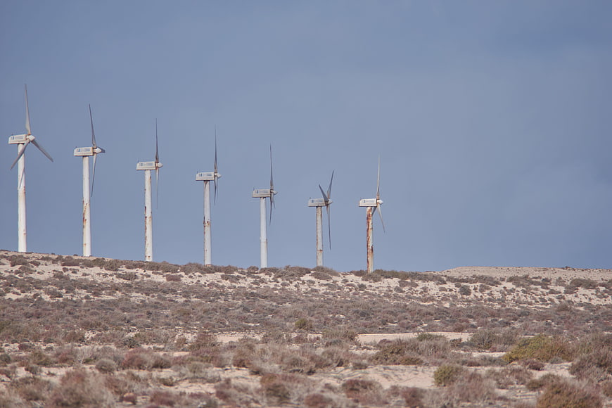 Row of Rusty Wind Turbines on Desert Hilltop