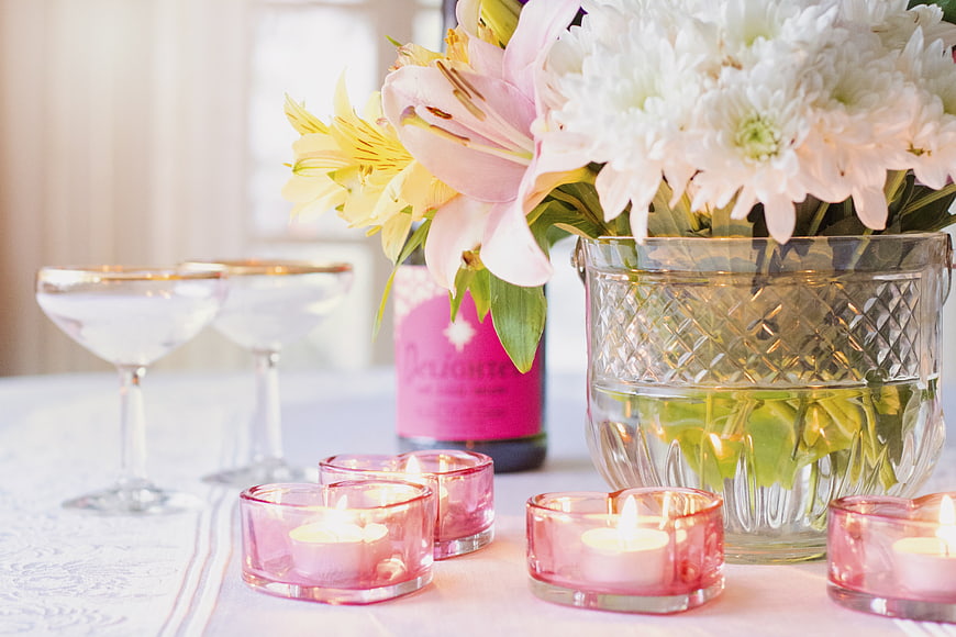 Romantic table setting with pink candles, flowers, and champagne glasses