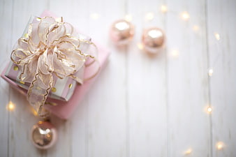 Pink Christmas Gift Box With Ribbon And Ornaments On White Wood