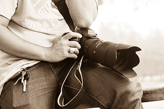 Photographer holding Canon camera with telephoto lens