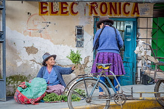 Peruvian women selling herbs on street with bicycle