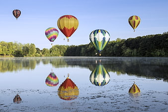 Colorful Hot Air Balloons Reflecting in Misty Lake