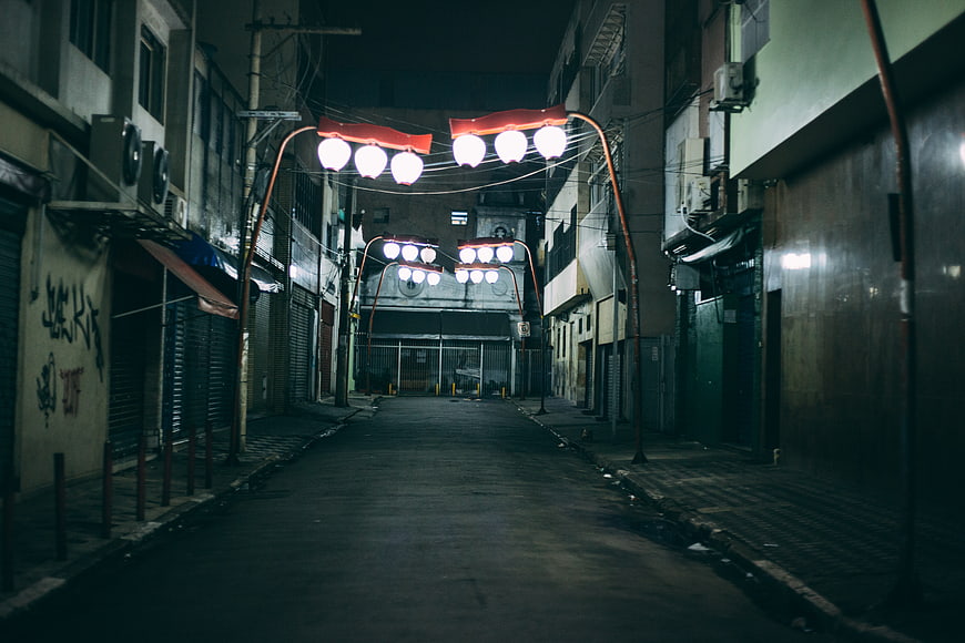 Empty Urban Alley at Night with Glowing Street Lamps