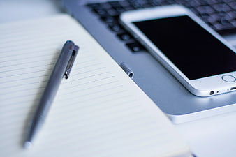 Gray Pen on Notebook with Smartphone and Laptop
