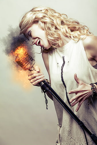 Passionate female singer with flaming vintage microphone