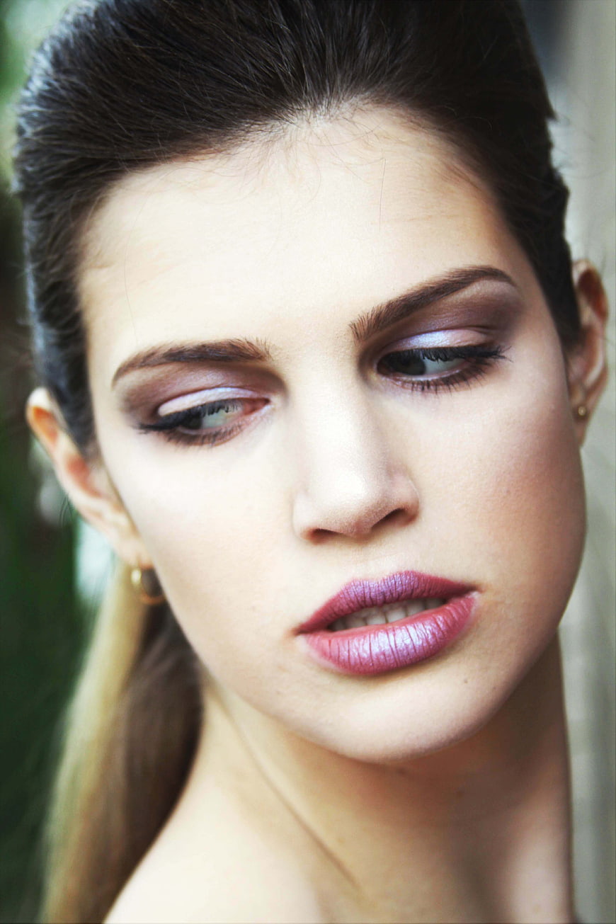 Close-up portrait of a woman with bold makeup looking away