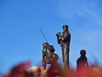 Bronze Soldier Statues Against Blue Sky
