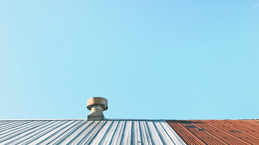 Rusty Roof Vent Against Clear Blue Sky