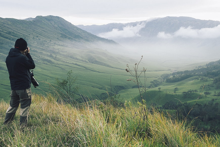 Photographer Capturing Misty Mountain Valley Panorama in Indonesia
