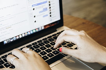 Close-up of hands typing on a laptop keyboard