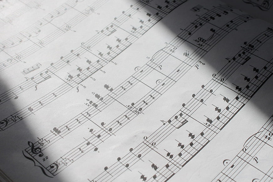 Close-up of classical piano sheet music with dramatic diagonal shadow