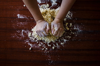 Child Hands Kneading Dough on Wooden Table