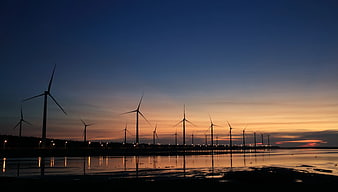 Wind Turbines Silhouette at Sunset Over Water