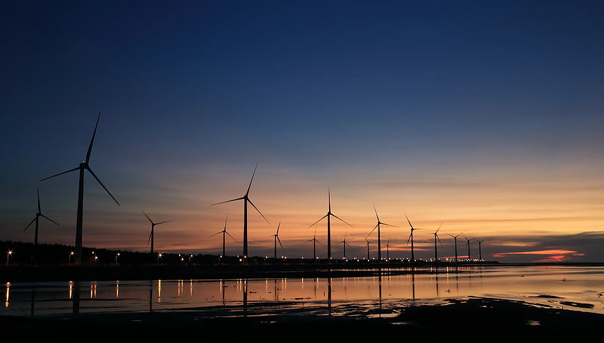 Wind Turbines Silhouette at Sunset Over Water