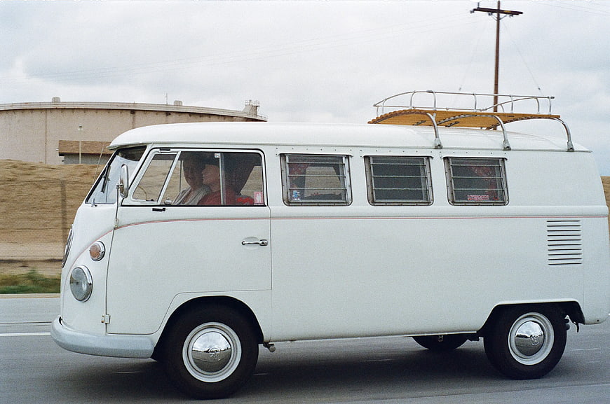 Vintage White Volkswagen T2 Bus Driving on Highway