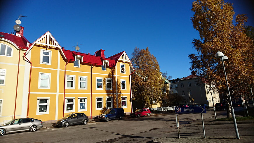 Yellow apartment building with red roof on sunny autumn day
