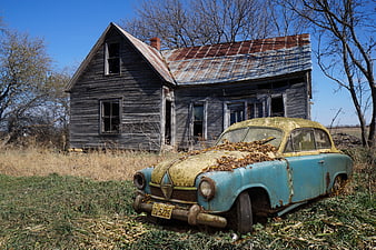 Abandoned Rusty Vintage Car in Front of Dilapidated House