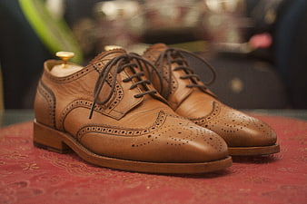 Brown Leather Wingtip Brogue Shoes on Red Patterned Surface