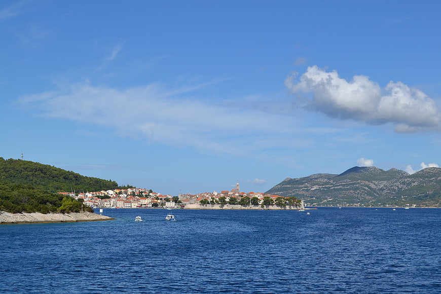 Coastal town with red roofs on a sunny blue sea day