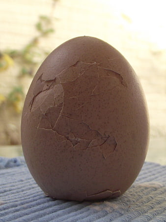 Cracked brown egg shell on blue textured fabric