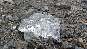 Clear Glacier Ice Chunk on Rocky Gravel Shore