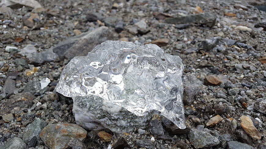 Clear Glacier Ice Chunk on Rocky Gravel Shore