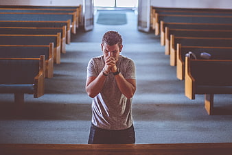 Man Praying in Church Aisle