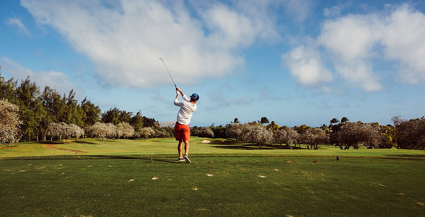 Male Golfer Hitting A Drive On A Sunny Golf Course