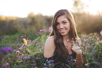 Smiling Brunette Woman in Wildflower Field at Sunset