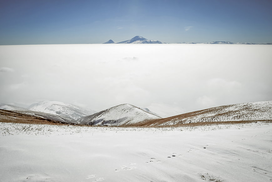 Snowy mountain landscape above sea of clouds