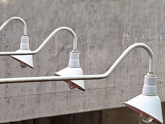 White industrial pendant lights against concrete wall