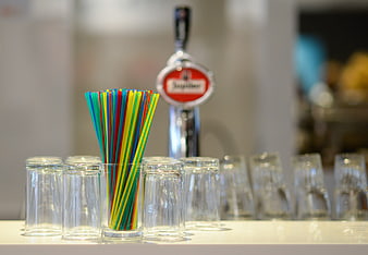 Colorful Straws in Glass with Beer Tap Background