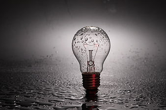 Wet Light Bulb with Water Droplets on Dark Surface