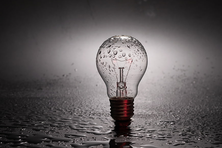 Wet Light Bulb with Water Droplets on Dark Surface