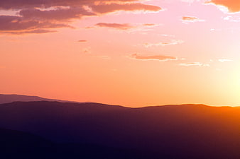 Vibrant Pink and Orange Sunset Over Mountain Silhouettes