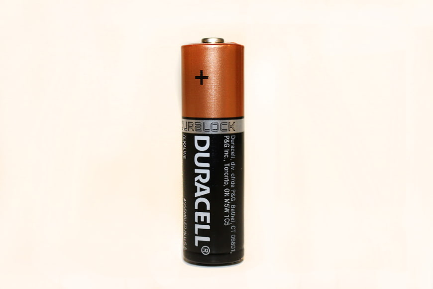 Single Duracell Alkaline Battery Standing Upright On White Background