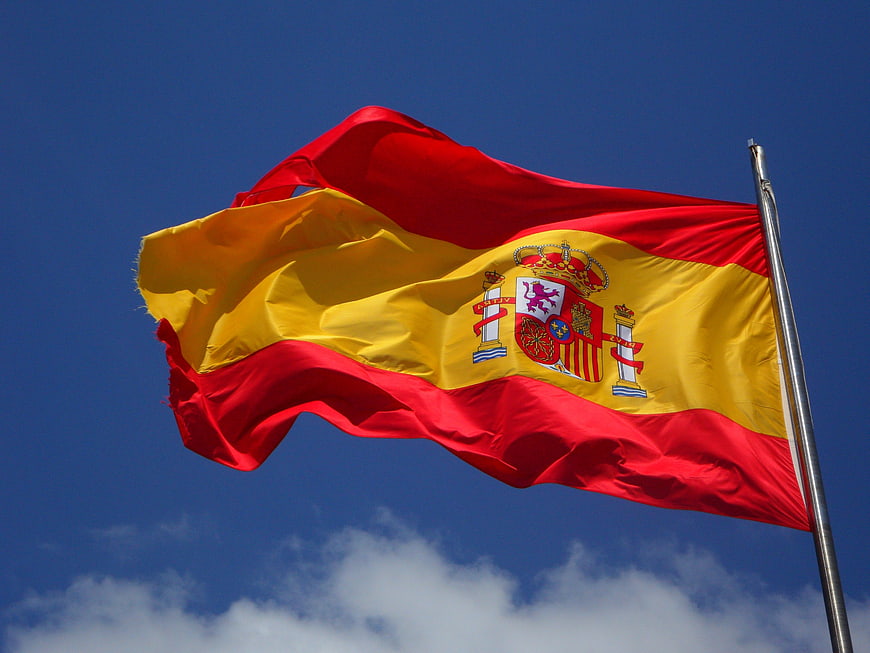 Spanish Flag Waving Against Blue Sky