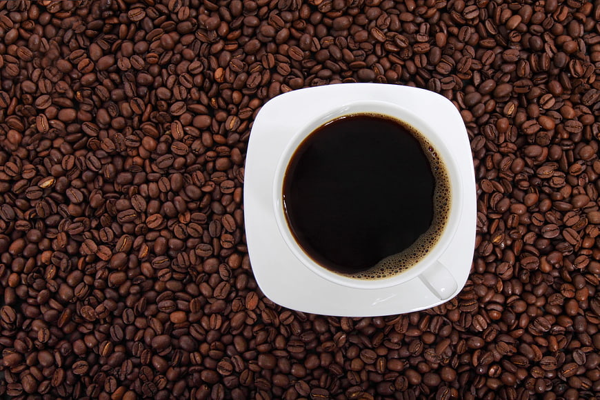 Top View of Black Coffee Cup on Roasted Beans