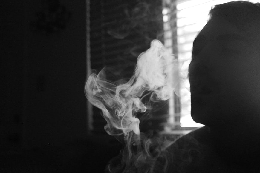 Silhouette of Man Smoking with Swirling Smoke